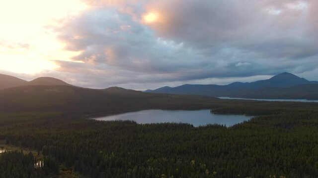 View of Lakes from Above surrounded by Forest and Mountains at Twilight. Aerial Drone Shot taken in Canadian Nature. South of Whithorse, Yukon, Canada. 4K