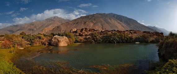 Central Asia. Tajikistan. A picturesque lake with swampy shores in a deserted mountain valley along the Pamir highway.