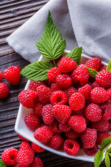 juicy fresh natural raspberries on a dark wooden rustic background