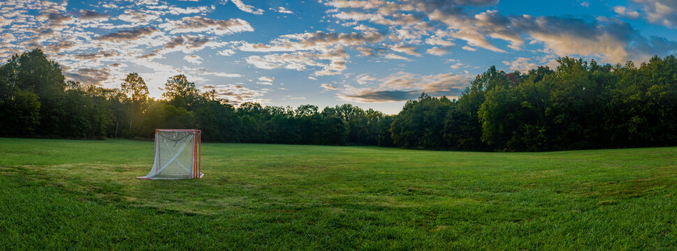 Panorama of a lawn field with lacrosse goals stored and locked together in Veteran's park in Lexington, KY USA during sunrise