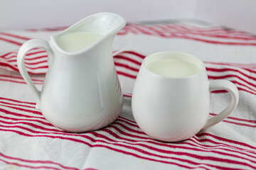 white jugs with milk on tea towel