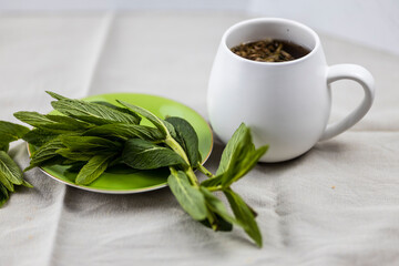 cup of herbal tea on white table cloth