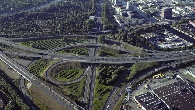 Aerial view of Amsterdam A10 an d A2 motorway interchange on a sunny day. Many trucks, cars and trains passing by. Netherlands. Transportation.

