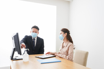 Fototapeta premium 感染症対策をしてオフィスで働くビジネスパーソン
