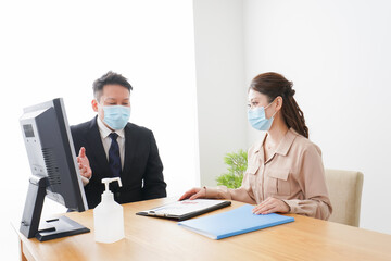 感染症対策をしてオフィスで働くビジネスパーソン