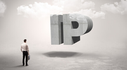 Rear view of a businessman standing in front of IP abbreviation, modern technology concept
