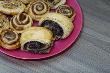 Baked buns stuffed with poppy, cinnamon and walnuts. Lie on a plate.