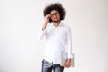 Latin American man holding a laptop, fixing glasses, neutral background 