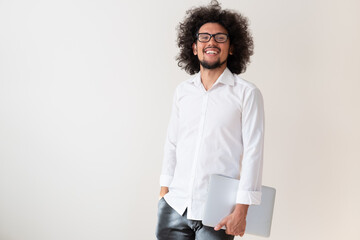 Latin american man, smiling expression, holding a laptop
