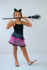 funny child girl in witch costume for Halloween over white background