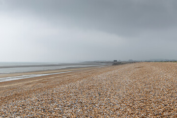 Empty shingle beach with grey sky in Rye, East Sussex, England