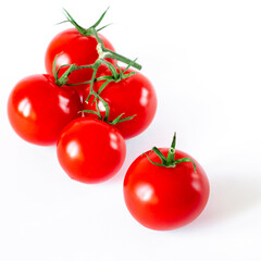 A branch of cherry tomatoes lies on a white background