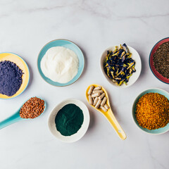 Variety of healthy food supplements such as blue matcha, butterfly pea flowers, collagen powder, spirulina powder, vitamins for vegans and vegetarians, flax and chia seeds,