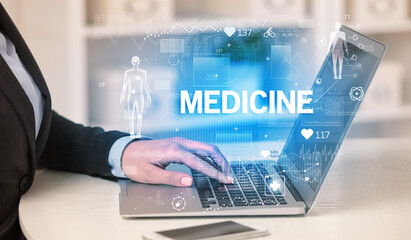 Doctor working a health check with MEDICINE inscription, recording medical test results