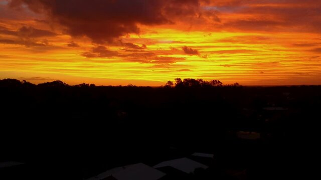 Epic aerial sunset reveal. Full orange sky