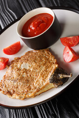 Filipino eggplant omelette Tortang Talong close-up in a plate on the table. Vertical