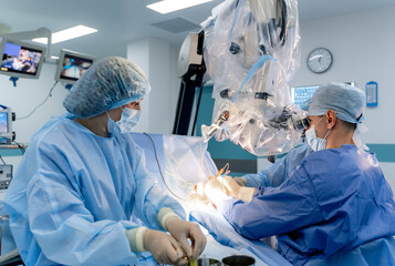 Surgical room in hospital with robotic technology equipment. Machine arm in neurosurgeon`s hands....
