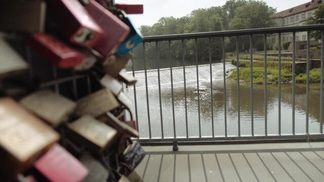 locks on a bridge with a small waterfall in the background FOCUS PULL