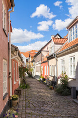 Fototapeta na wymiar Idyllic street with old crooked houses at the old town of Aalborg, Denmark