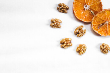 Dried oranges with nuts layout. Autumn / winter theme background. Corner border from top view, empty space for text.