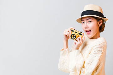 Asian beautiful woman holding camera and wearing hat which excited expression in front of white background as copy space.