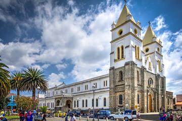 Guaranda, Bolivar province, Ecuador - November 2013: Guaranda's Cathedral during a sunny and cloudy morning. Located in the town's center plaza. - obrazy, fototapety, plakaty