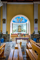 Guaranda, Bolivar Province, Ecuador - November 2013: Interior of Guaranda's cathedral , with religious decorations and statues, church pews, stained windows and arches. Daytime.