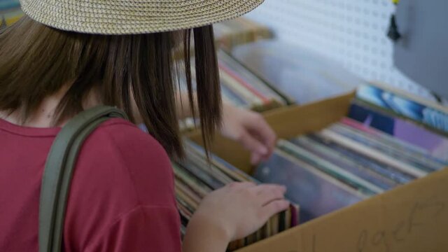 Close up of girin hat looking through old vinyl records in market