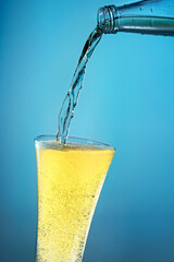 Fruit sparkling water is poured into a glass.