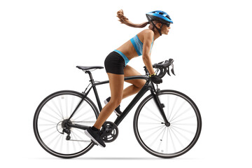 Full length profile shot of a woman in sportswear riding a bicycle with a helmet