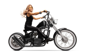 Naklejka na ściany i meble Full length profile shot of a female biker with long hair riding a chopper motorbike
