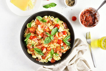Tomato and bacon pasta with parmesan cheese and basil leaves