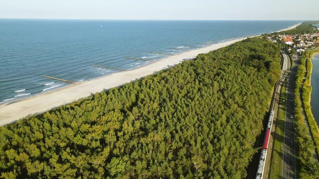 Aerial Cinematic view on road between green forest Baltic Sea and guld of Gdansk, Kuznica Poland