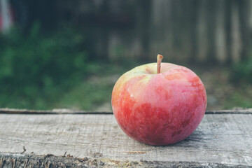 pink fruit apples on wooden boards in the yard in the village