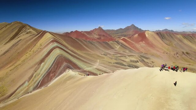Aerial View Of Hikers Trekking To Rainbow Mountain Peak In The Peruvian Andes