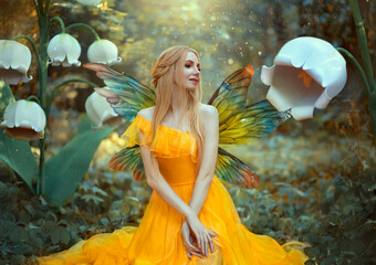 Portrait of happy fantasy woman blonde forest fairy. Fashion model in a bright yellow dress with...