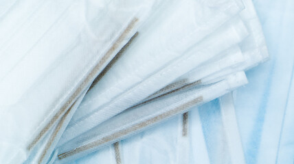 Coronavirus protection. Antiviral protective medical face masks with ear loops. Surgical mask background. Respiratory syndrome, coronavirus disease COVID-19. Many folded medical masks.