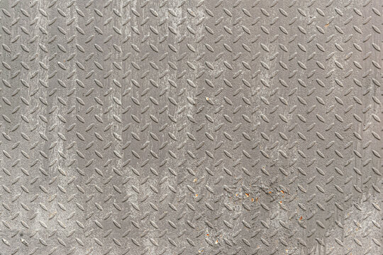 abstract background of old rusty metal plate with diamond pattern painted grey close up