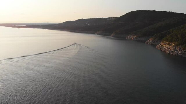 High Straight Shot Of A Boat Following The Cliffs On Lake Travis. Shot At Golden Hour In Austin Texas On 9/10/20