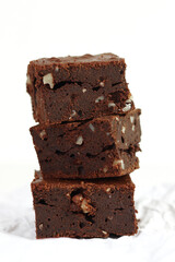 Front view of homemade chocolate brownie with walnut on white background.
