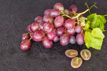 a bunch of pink grapes on a dark background. grapes close-up. background with red grapes.