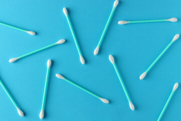 Flat lay composition with cotton swabs on blue background. Top view ear sticks