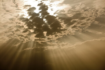 sky with black clouds and rays of light passing between them at sunset