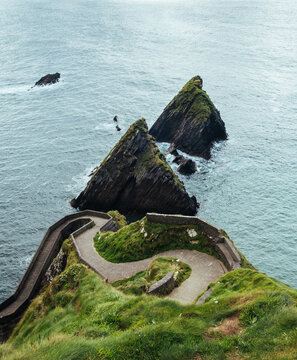 Windy coastal path along the grass cliffs above the ocean