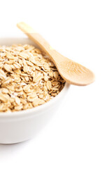 Oat flakes on a bowl and a wooden spoon