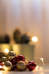 Christmas decorations inside a glass jar and warm lights in the background.