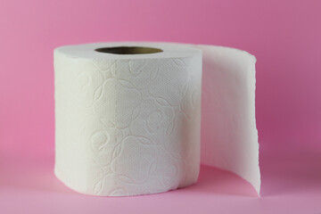 A roll of toilet paper on a pink background. Hygiene products.