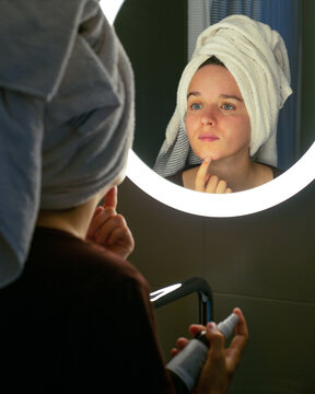 Young woman checking her skin. Skin care concept.