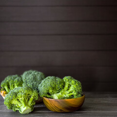fresh broccoli in a wooden bowl and on a table on a wooden background. still life with broccoli. broccoli close-up. cabbage on the table.