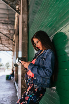 Beautiful hispanic woman scrolling on her phone